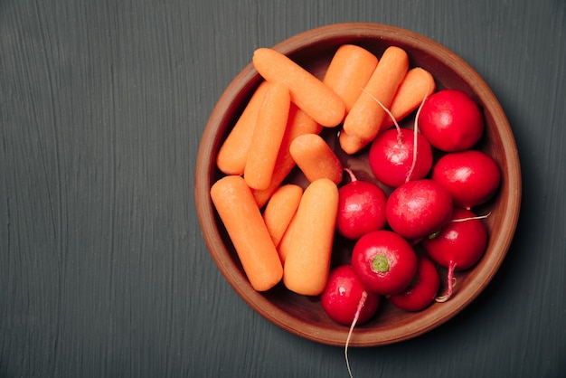Fresh radishes and carrots on a plate
