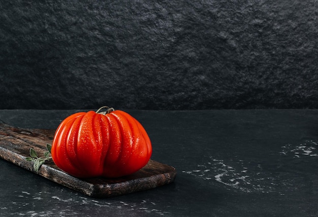 Fresh Raf Coeur De Boeuf tomato on a wooden plank grey background rustic concept stock photo