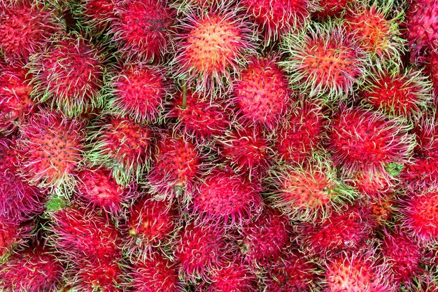 背景のためにタイの市場で新鮮なランブータンの甘いおいしい果物
