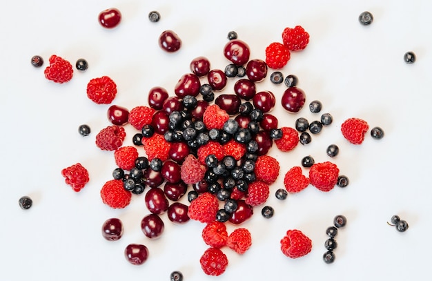 fresh raspberries, blueberries and cherries on white 