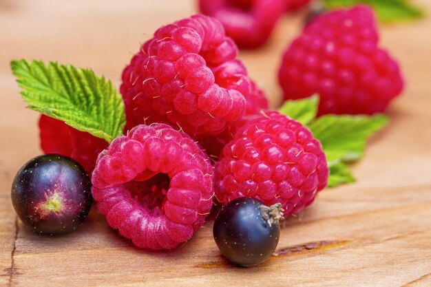 Fresh raspberries and currants on a wooden