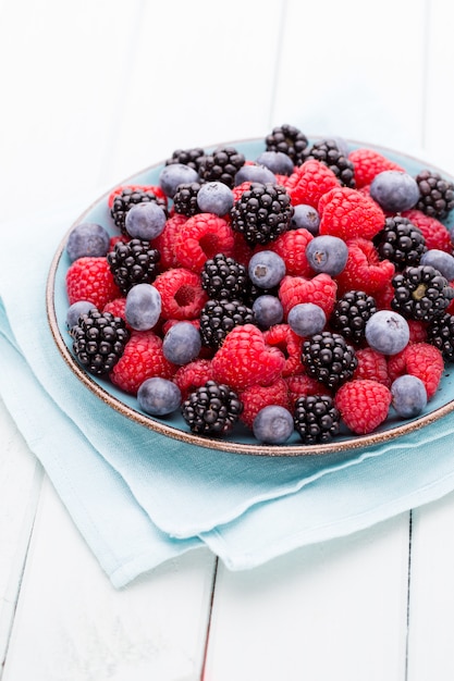 Fresh raspberries in a plate on a vintage background