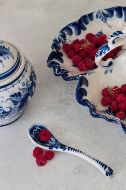 Photo fresh raspberries in traditional gzhel.