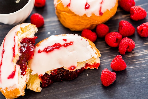 Fresh raspberry jelly filled donuts with white glazing on top.