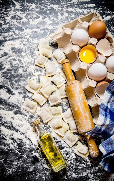 Fresh ravioli with a rolling pin, eggs and olive oil.