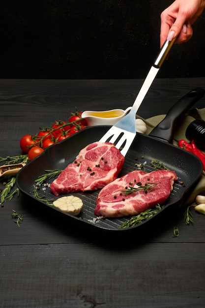Fresh raw beef or pork steaks on frying pan