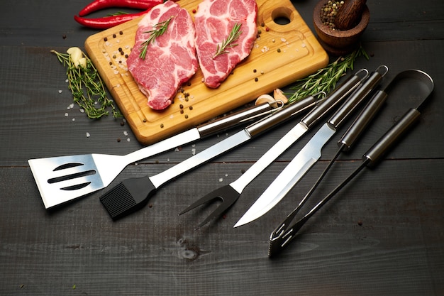 Photo fresh raw beef or pork steaks on wooden cutting board