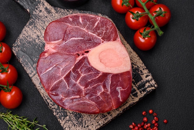 Fresh raw beef steak with bone or ossobuco with salt spices and herbs