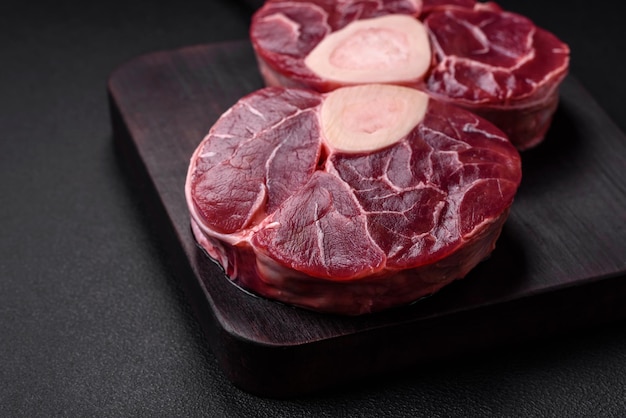 Photo fresh raw beef steak with bone or ossobuco with salt spices and herbs