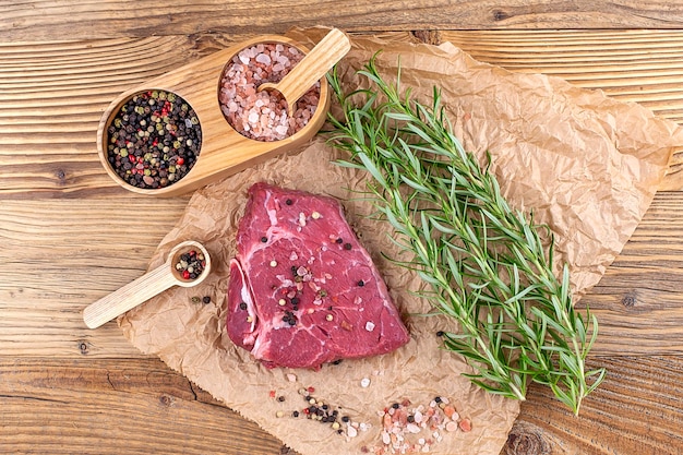 Fresh raw beef steak with rosemary and spices