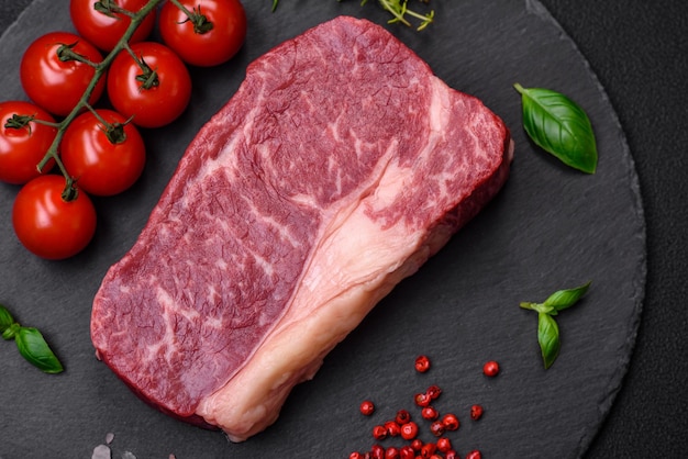 Fresh raw beef striploin steak with salt spices and herbs