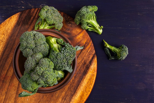 Fresh raw broccoli on a wooden table, top view, copy space