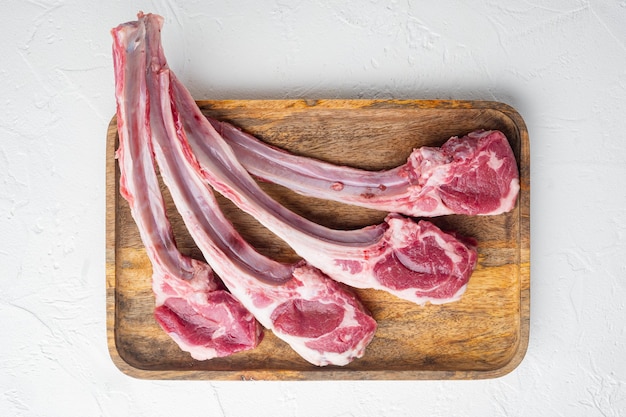 Foto crudo fresco macellai agnello costolette di manzo impostato, sul tavolo di pietra bianca, vista dall'alto laici piatta