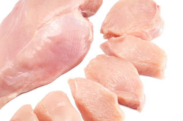 Fresh raw chicken breast fillet whole and sliced isolated closeup on white background clipping path