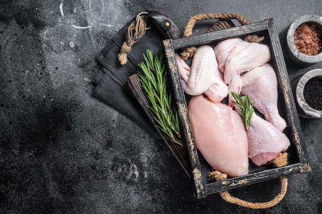 Photo fresh raw chicken meat and chicken parts drumstick breast fillet wing thigh black background top view copy space