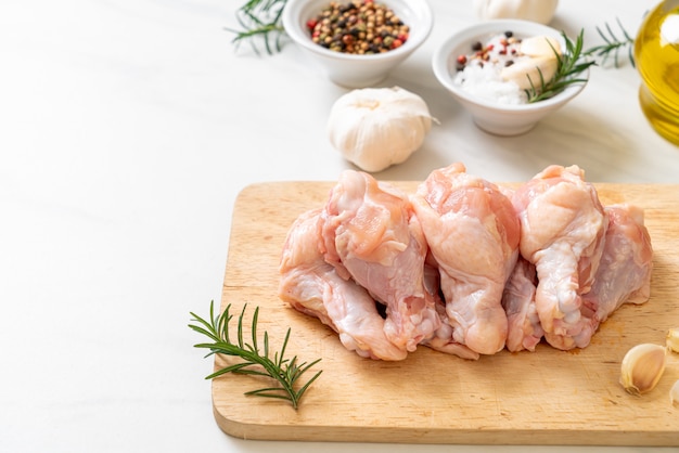 fresh raw chicken wings (drumette or drumstick) on wooden board