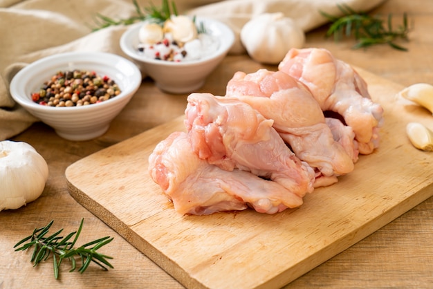 Ali di pollo fresche crude (drumette o bacchetta) su tavola di legno