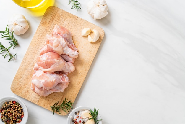 fresh raw chicken wings (drumette or drumstick) on wooden board