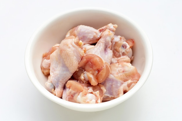 Fresh raw chicken wings (wingstick) in white plate on yellow background.