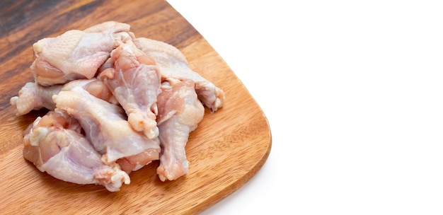 Fresh raw chicken wings (wingstick) on wooden cutting board on white background.