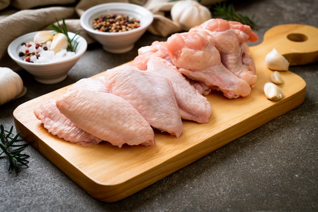 fresh raw chicken wings on wooden board