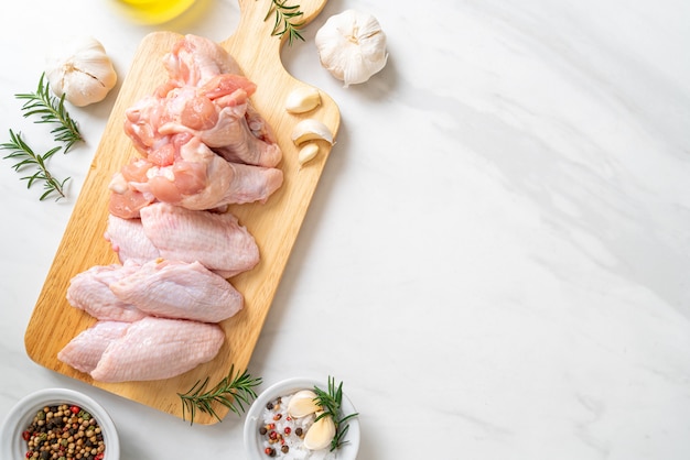 Photo fresh raw chicken wings on wooden board