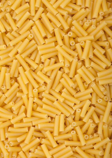 Fresh raw classic macaroni pasta ias texture background Top view