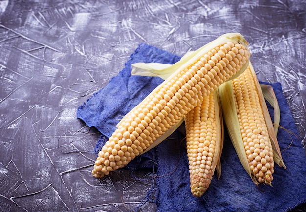 Fresh raw corn on concrete table. Selective focus