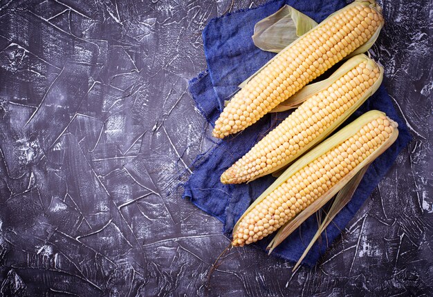 Fresh raw corn on concrete table. Selective focus