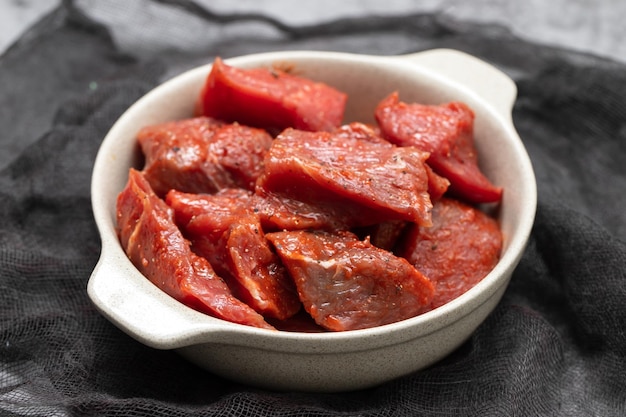 Fresh raw cube of beef in white bowl