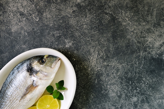 Fresh raw dorado fish with lime slices and mint leaves