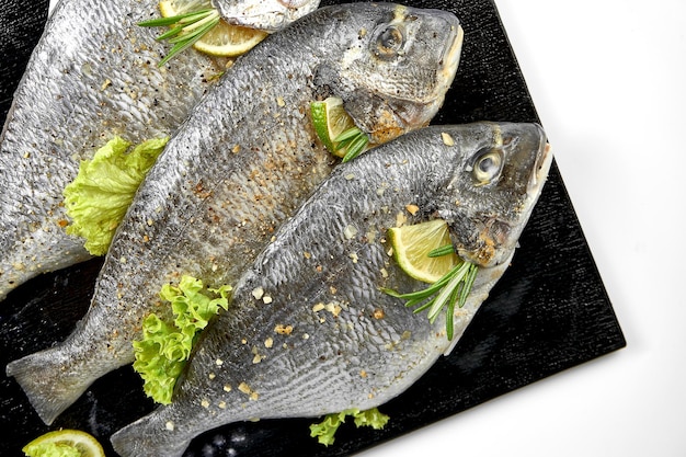 Fresh raw dorado in spices on a black board Ready to cook White background Selective focus