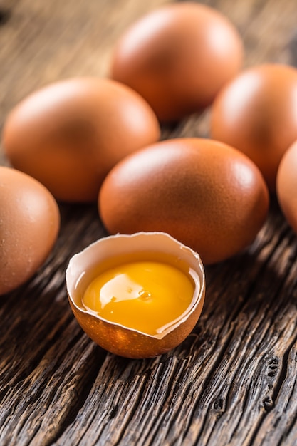 Fresh raw eggs on rustic wooden table.