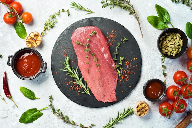 Fresh and raw fillet meat Whole piece of beef tenderloin steaks set with spices and herbs Meat On a stone background