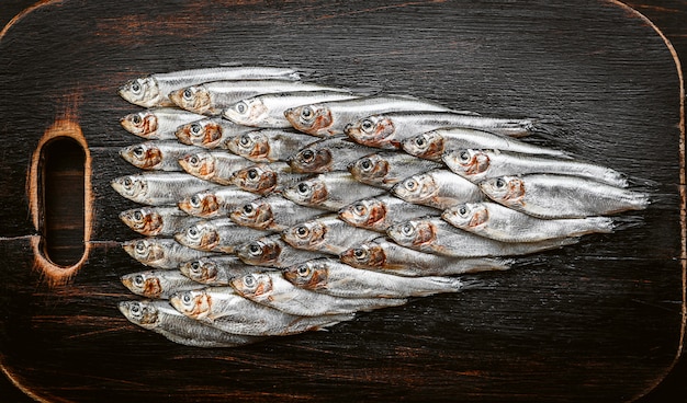 Fresh raw fish anchovy and sprat on a wooden surface