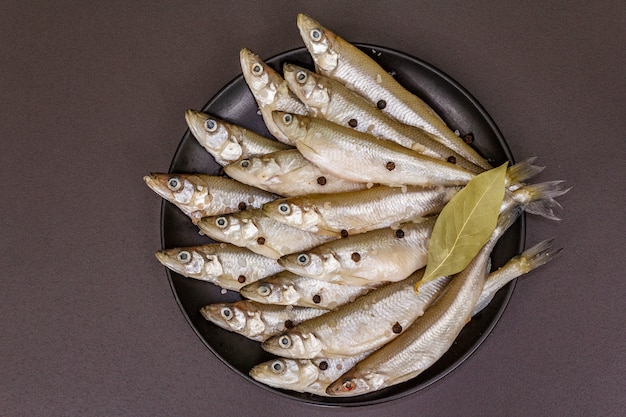 Корюшка свежей сырой рыбы или сардины, готовые к приготовлению