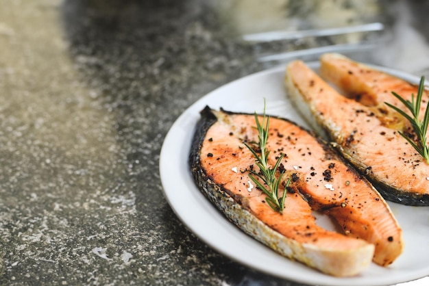 Fresh raw fish with lemon rosemary and lettuce on wooden cutting board