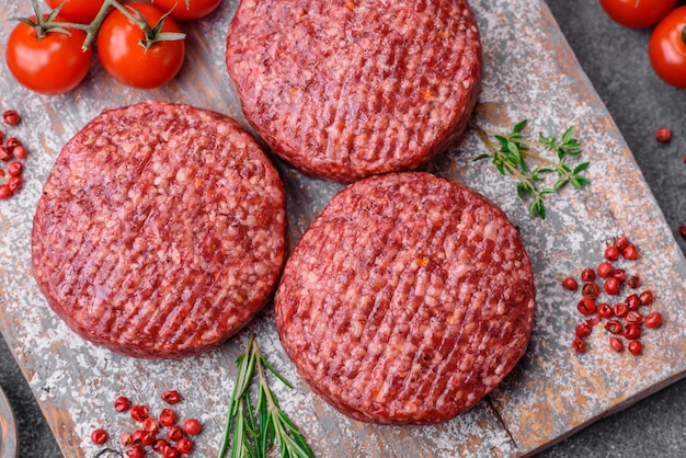 Fresh raw ground beef burger patty with salt and spices