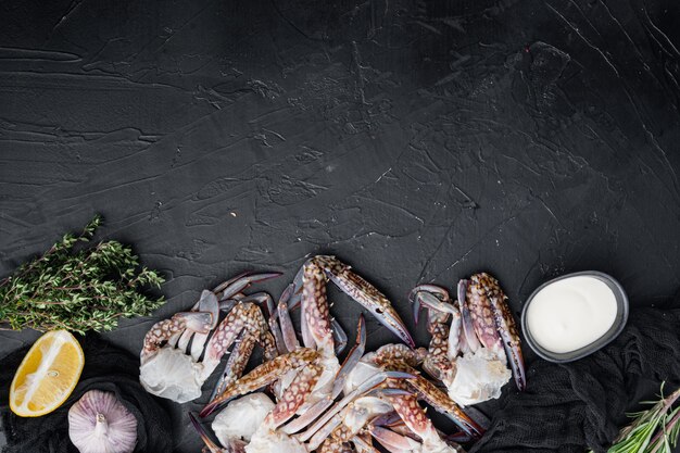 Crudo fresco granchio di cavallo, granchio blu, set di granchio fiore, su sfondo nero, vista dall'alto laici piatta, con copyspace e spazio per il testo