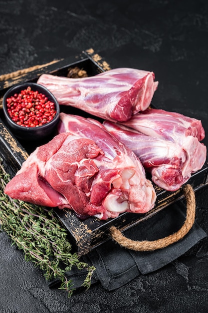 Fresh Raw lamb shanks with herbs and spices mutton meat Black background Top view