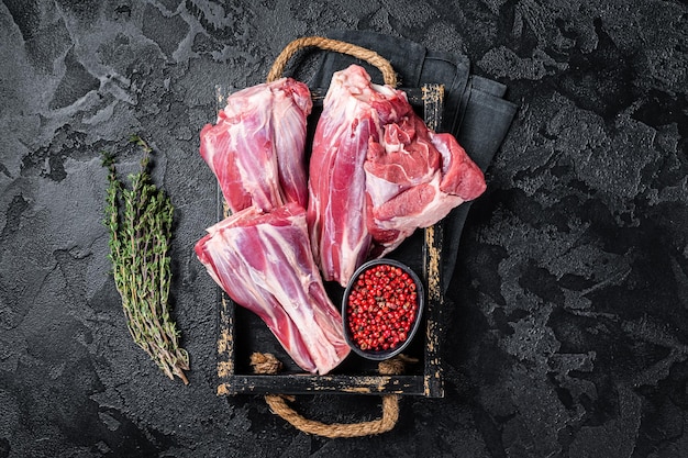 Fresh Raw lamb shanks with herbs and spices mutton meat Black background Top view