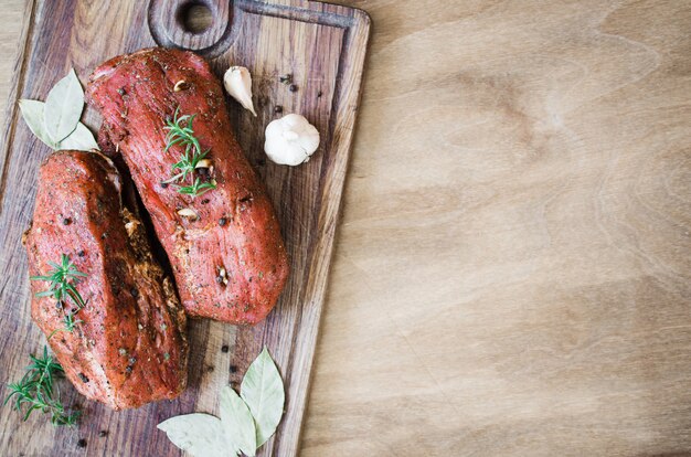 Fresh Raw Marinated Meat on a Wooden Table.