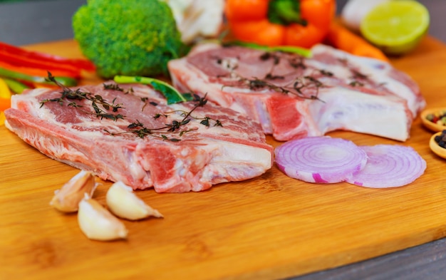 Fresh raw marinated pork steak with herbs and condiments ready for barbecue