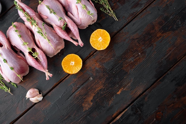 Photo fresh raw meat quails with herbs flat lay on dark wooden background with space for text