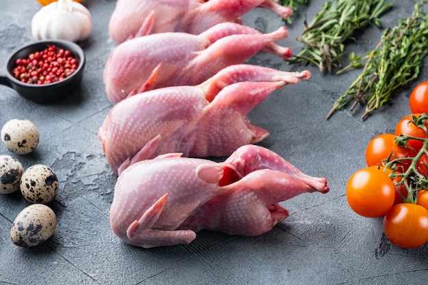 Photo fresh raw meat quails with herbs, on grey table
