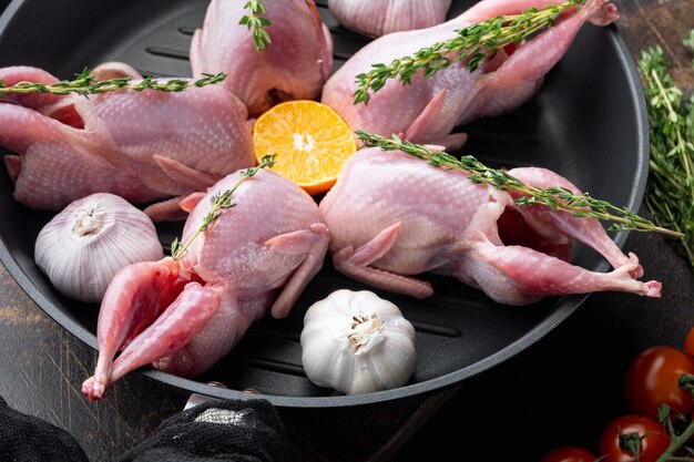 Fresh raw meat quails with herbs, on old rustic background