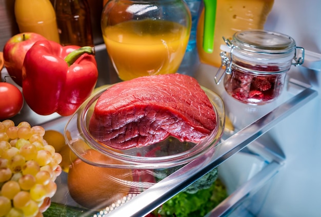 Fresh raw meat on a shelf open refrigerator