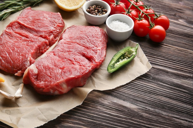 Fresh raw meat and spices on wooden table