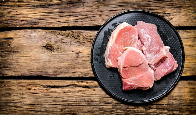 Fresh raw meat on a stand. On wooden background.