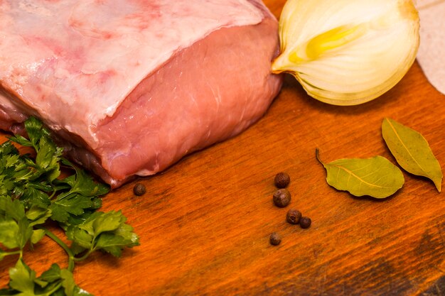 Fresh raw meat with spices on wooden background